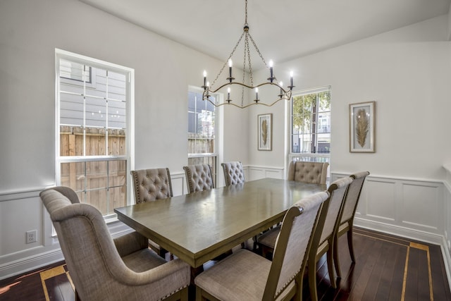 dining area with dark hardwood / wood-style floors and an inviting chandelier