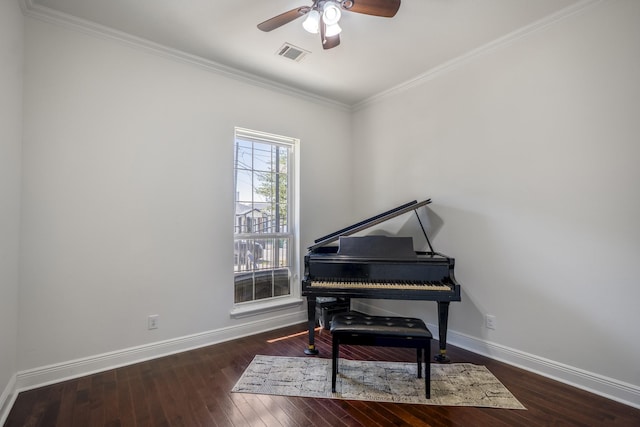 misc room with ceiling fan, dark wood-type flooring, and ornamental molding