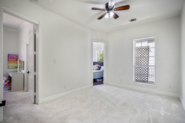 unfurnished bedroom featuring ceiling fan, light colored carpet, and multiple windows