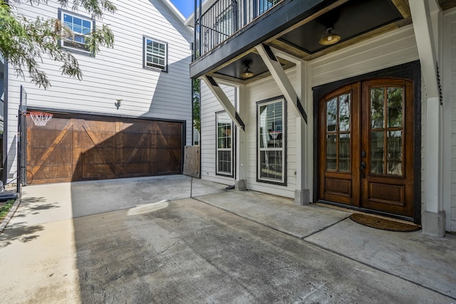 view of exterior entry with french doors and a balcony