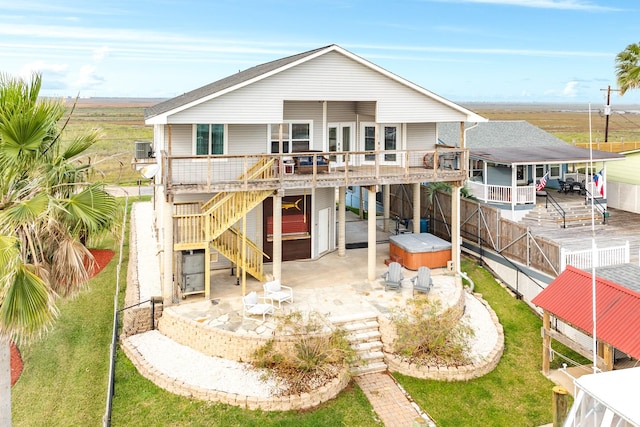 back of house with a deck, a hot tub, and a patio area