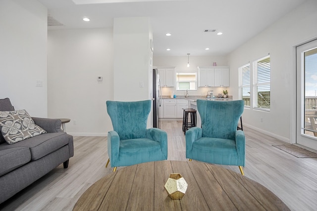 living room with sink and light hardwood / wood-style flooring