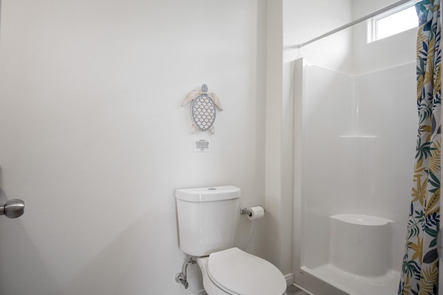 bathroom with toilet and a shower with curtain