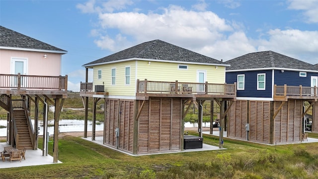 back of house with a yard, central AC, and a deck with water view