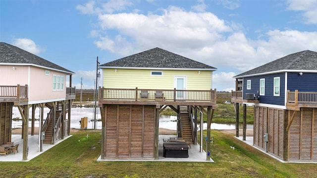 rear view of house with a lawn, central AC, and a deck with water view