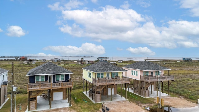 view of front of home with a garage, a deck with water view, and a carport