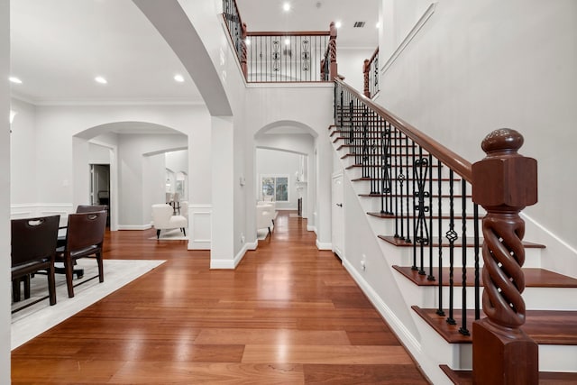 foyer with hardwood / wood-style flooring and crown molding