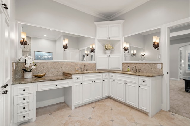 kitchen featuring tasteful backsplash, white cabinetry, dark stone countertops, and sink