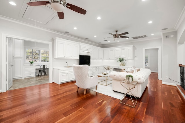 living room with hardwood / wood-style flooring, ceiling fan, and ornamental molding