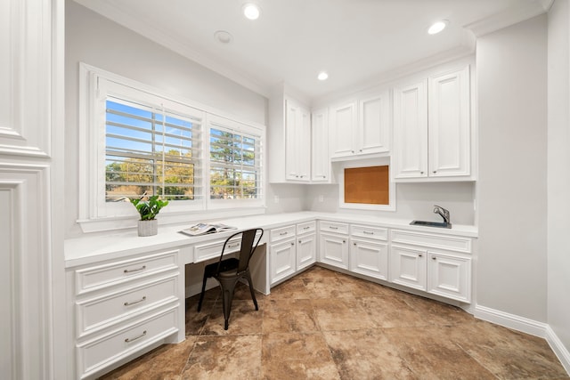 home office featuring built in desk, sink, and ornamental molding