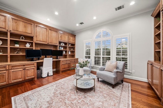 office with dark hardwood / wood-style floors, built in desk, and ornamental molding