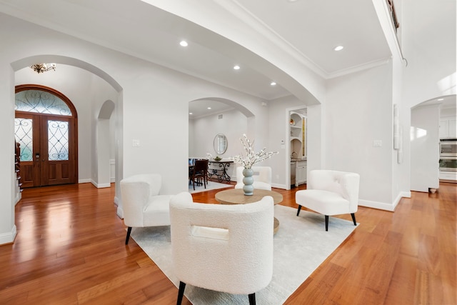 living room featuring crown molding, french doors, and light hardwood / wood-style floors