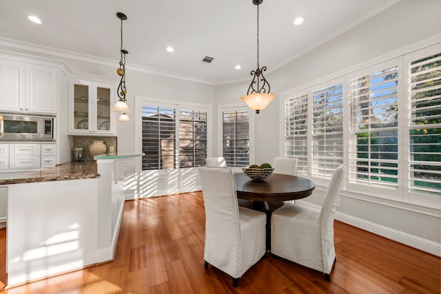 dining space with crown molding and hardwood / wood-style floors