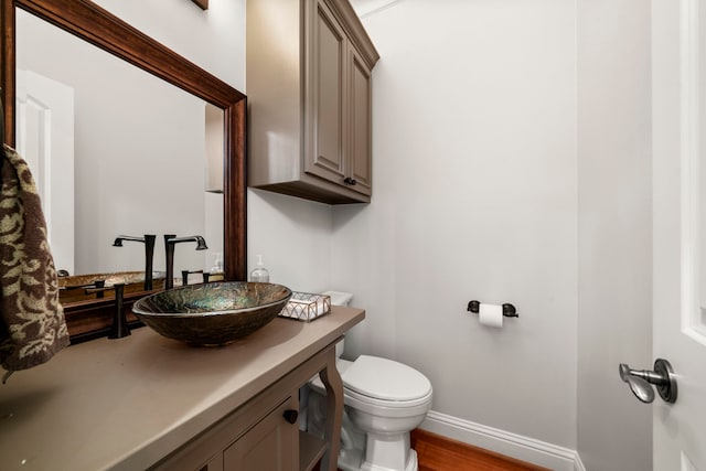 bathroom with vanity, wood-type flooring, and toilet