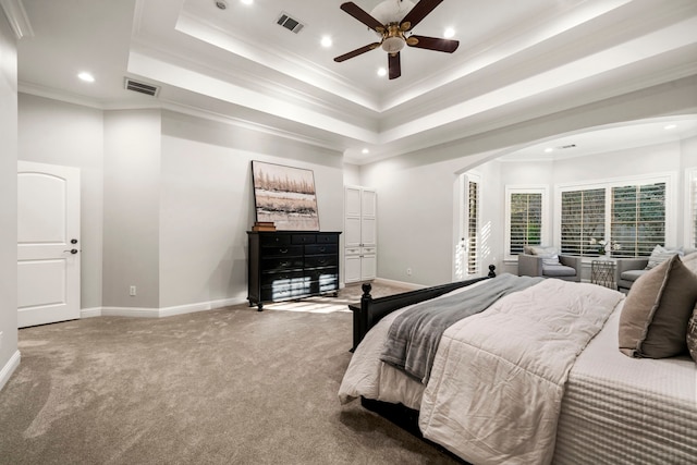 carpeted bedroom featuring a tray ceiling, ceiling fan, and ornamental molding