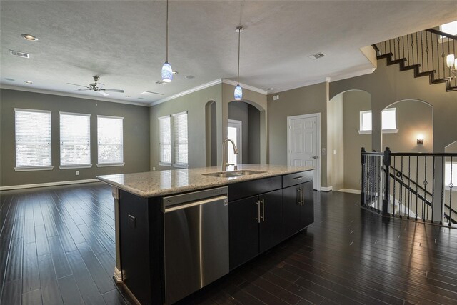 kitchen featuring dishwasher, sink, decorative light fixtures, and an island with sink