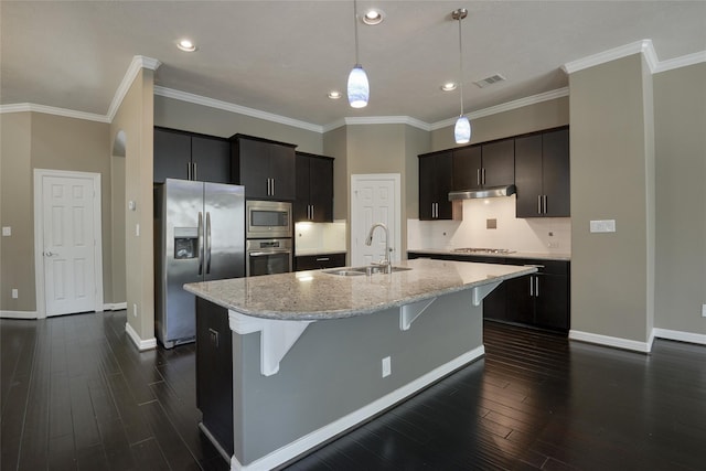 kitchen featuring backsplash, sink, an island with sink, decorative light fixtures, and stainless steel appliances