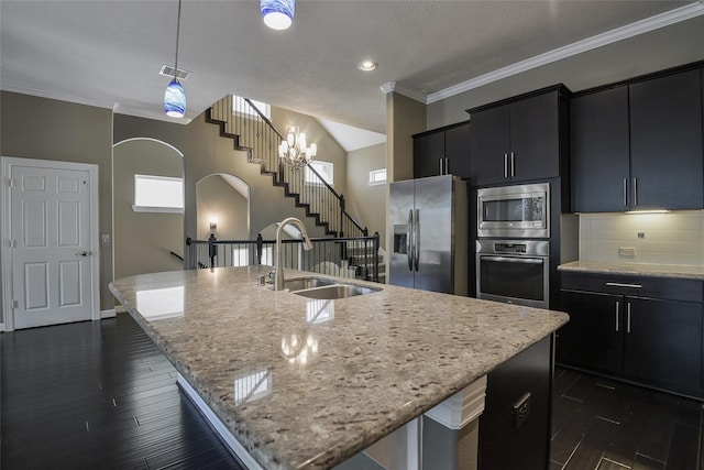 kitchen with a chandelier, sink, an island with sink, and stainless steel appliances