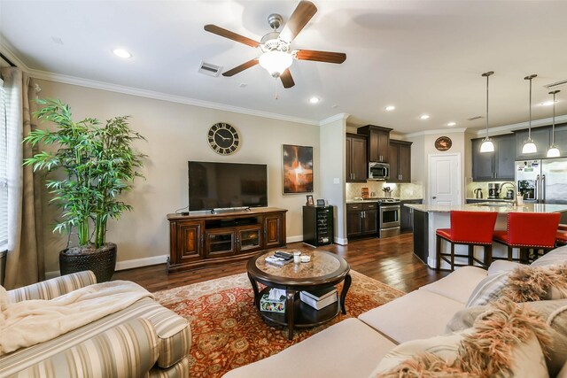 living room with dark hardwood / wood-style floors, ceiling fan, ornamental molding, and sink