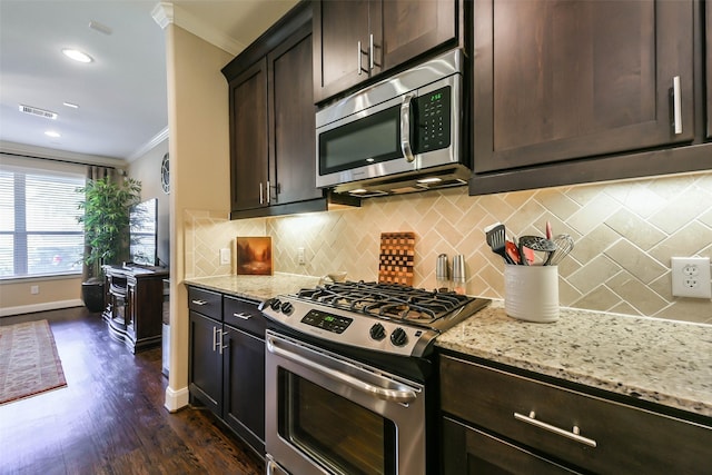 kitchen featuring appliances with stainless steel finishes, dark brown cabinetry, light stone counters, and crown molding