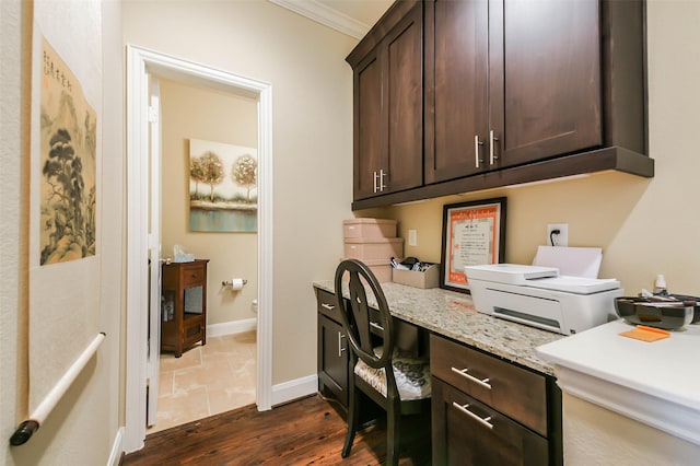 office space with crown molding, built in desk, and dark hardwood / wood-style floors