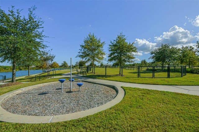 view of property's community featuring a lawn and a water view