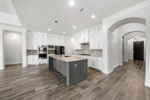 kitchen featuring stainless steel appliances, white cabinetry, a kitchen island with sink, and sink