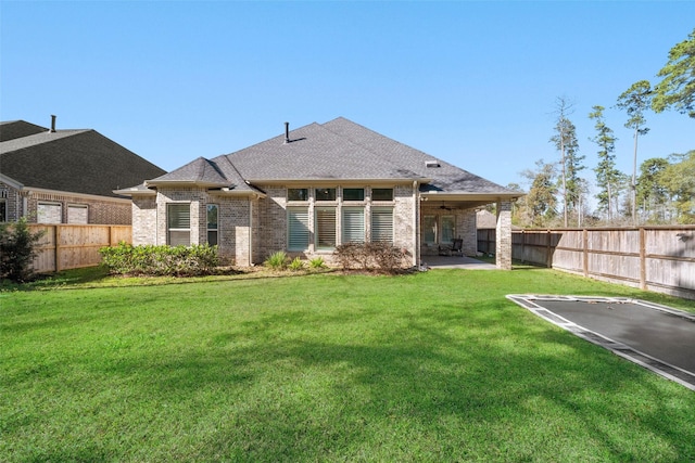 back of property with a lawn, ceiling fan, and a patio