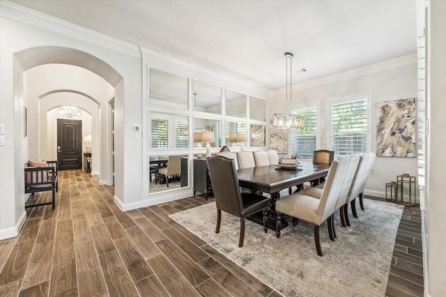 dining area featuring ornamental molding and an inviting chandelier