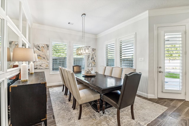 dining space featuring a chandelier, ornamental molding, and a healthy amount of sunlight