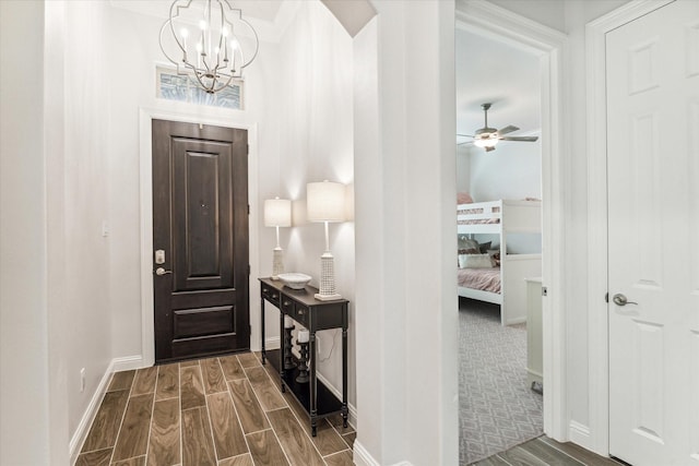 foyer with ceiling fan with notable chandelier