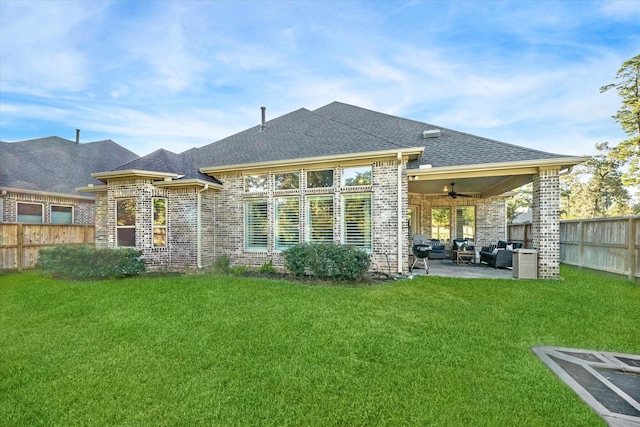 rear view of property with an outdoor hangout area, ceiling fan, a patio area, and a lawn