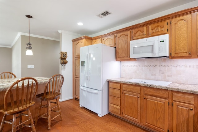 kitchen with decorative backsplash, light wood-type flooring, light stone counters, white appliances, and pendant lighting