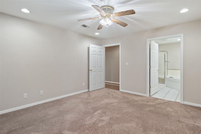 unfurnished bedroom featuring ceiling fan, light colored carpet, and connected bathroom