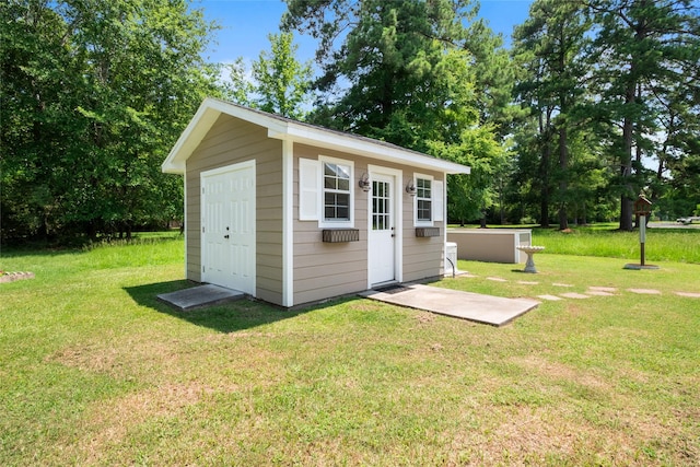 view of outbuilding featuring a lawn