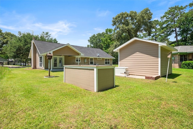 rear view of property featuring french doors and a lawn