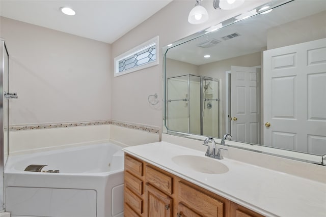 bathroom featuring vanity and independent shower and bath