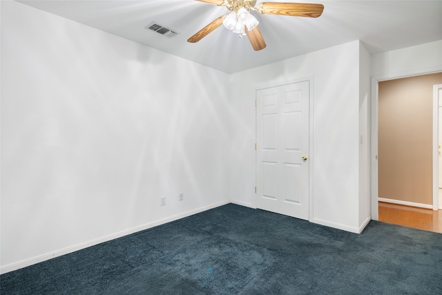 empty room featuring ceiling fan and dark colored carpet