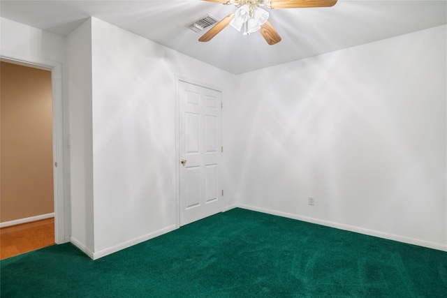 unfurnished room with dark carpet and ceiling fan