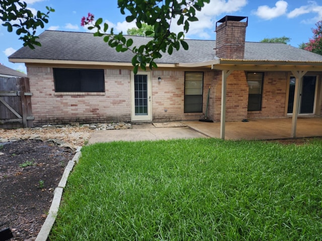 back of property with a lawn and a patio