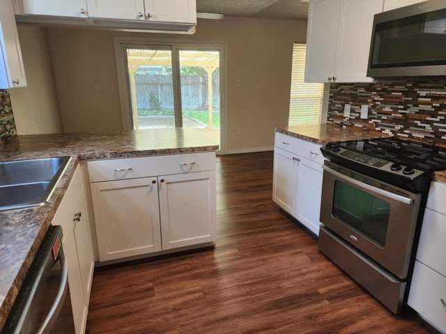 kitchen with kitchen peninsula, white cabinets, and stainless steel appliances