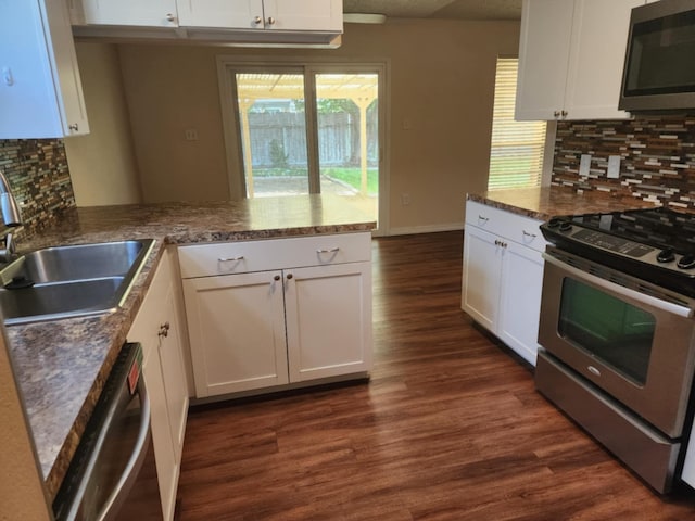 kitchen featuring tasteful backsplash, kitchen peninsula, white cabinetry, and appliances with stainless steel finishes