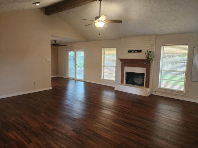 unfurnished living room with lofted ceiling with beams, dark hardwood / wood-style floors, ceiling fan, a fireplace, and a textured ceiling