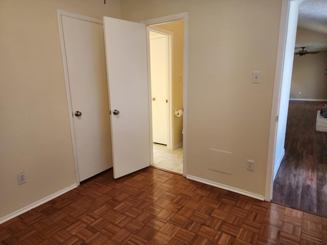 unfurnished bedroom with dark parquet flooring