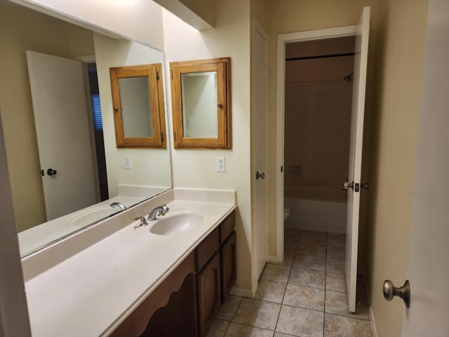 full bathroom with tiled shower / bath, tile patterned flooring, vanity, and toilet