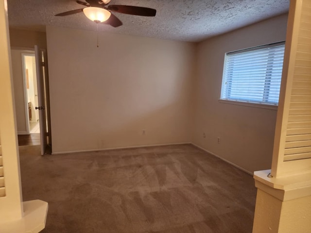 carpeted empty room featuring ceiling fan and a textured ceiling