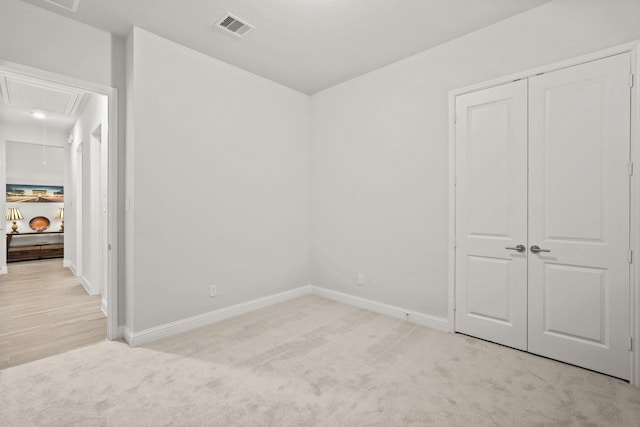 unfurnished bedroom featuring light colored carpet and a closet