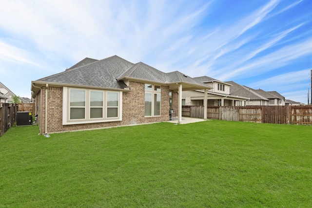 rear view of house featuring a lawn, a patio, and central AC