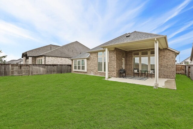 back of house with a patio and a lawn