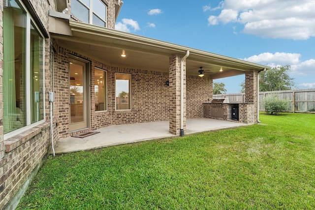 exterior space featuring ceiling fan, a yard, a patio, and an outdoor kitchen